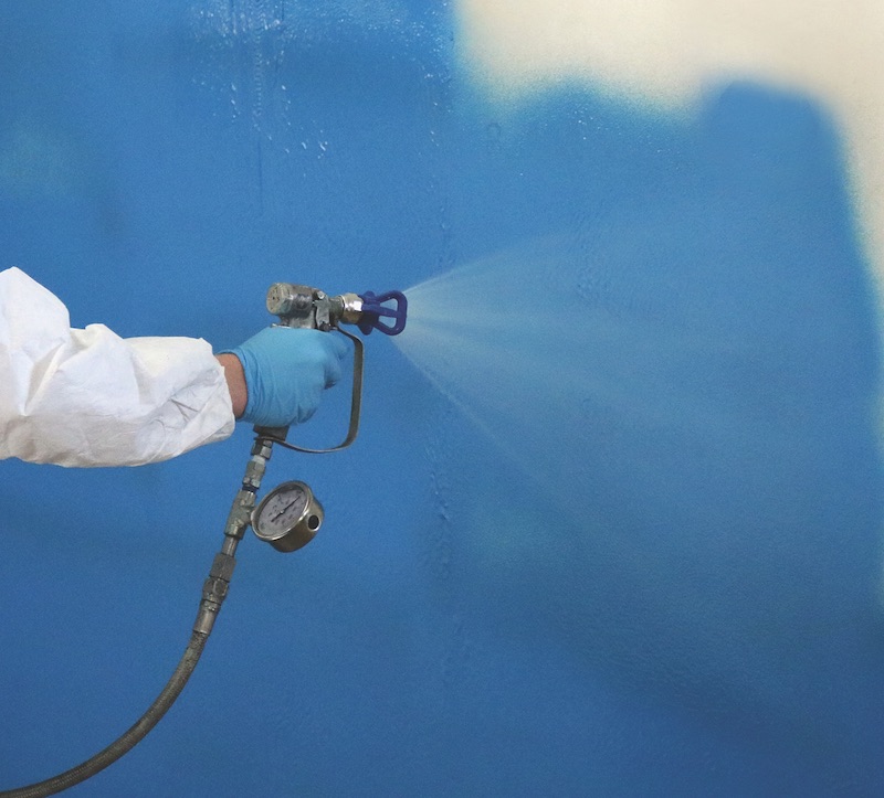 A worker spraying Sopraseal LM 204 VP on a wall