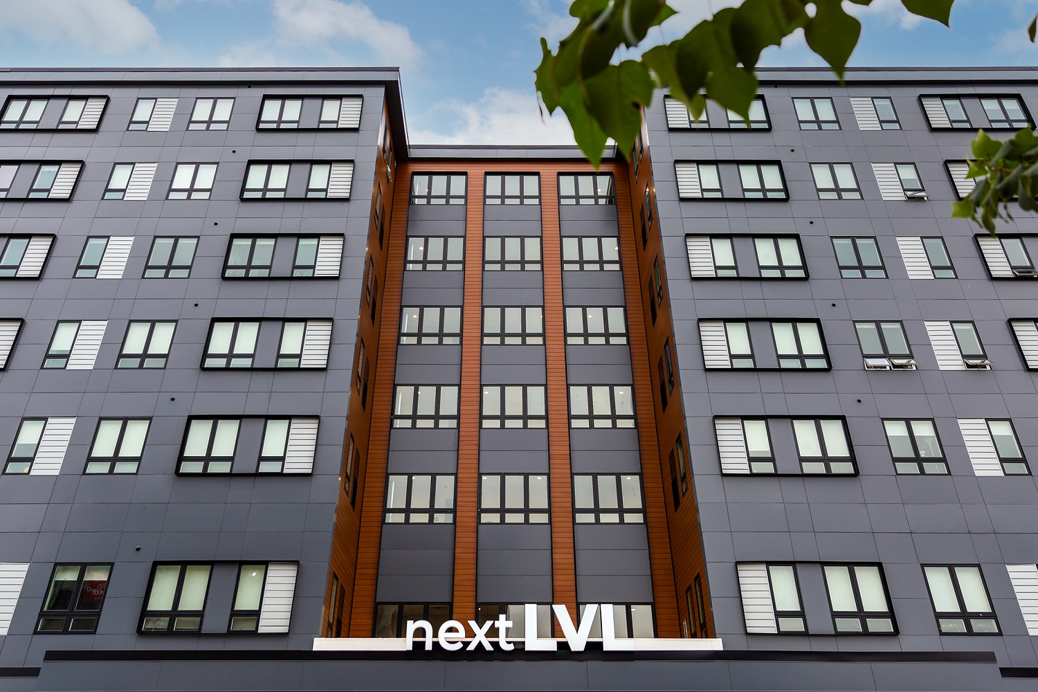 Exterior of a modern multifamily building with contrasting color scheme, sleek blackwindows and no visible HVAC equipment.