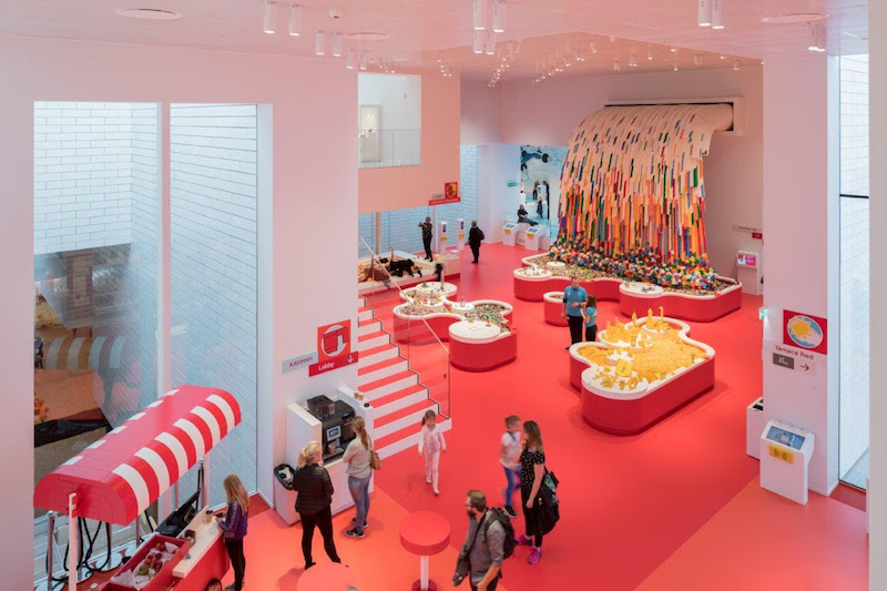 A red room in the LEGO House with a LEGO waterfall