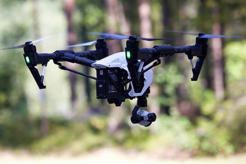 A drone flying in a wooded area