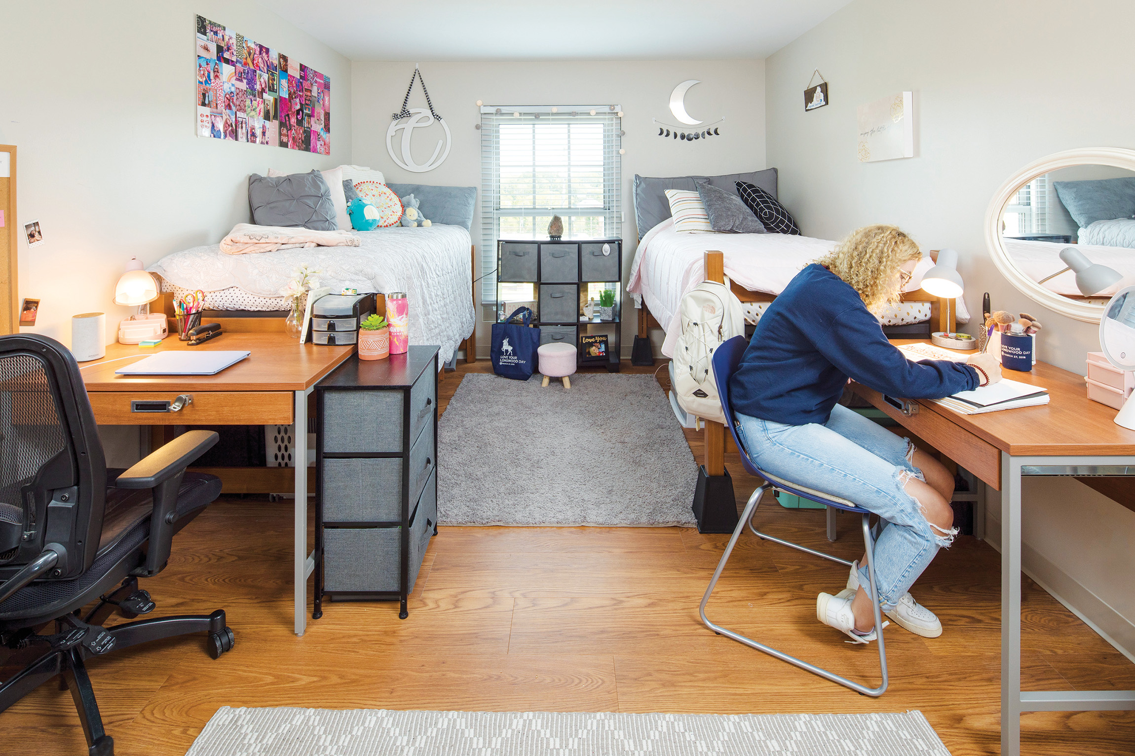 Interior dorm room with woman at desk