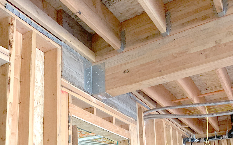 Glued-laminated mass timber beams used to simplify connections in multifamily housing development.