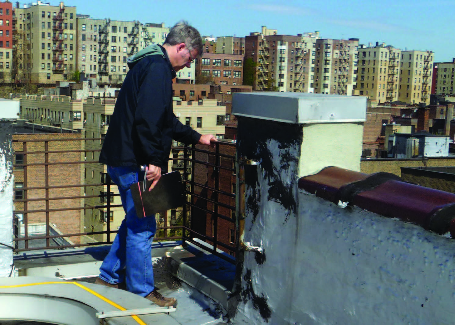Facilities professional inspects a roof railing system. 