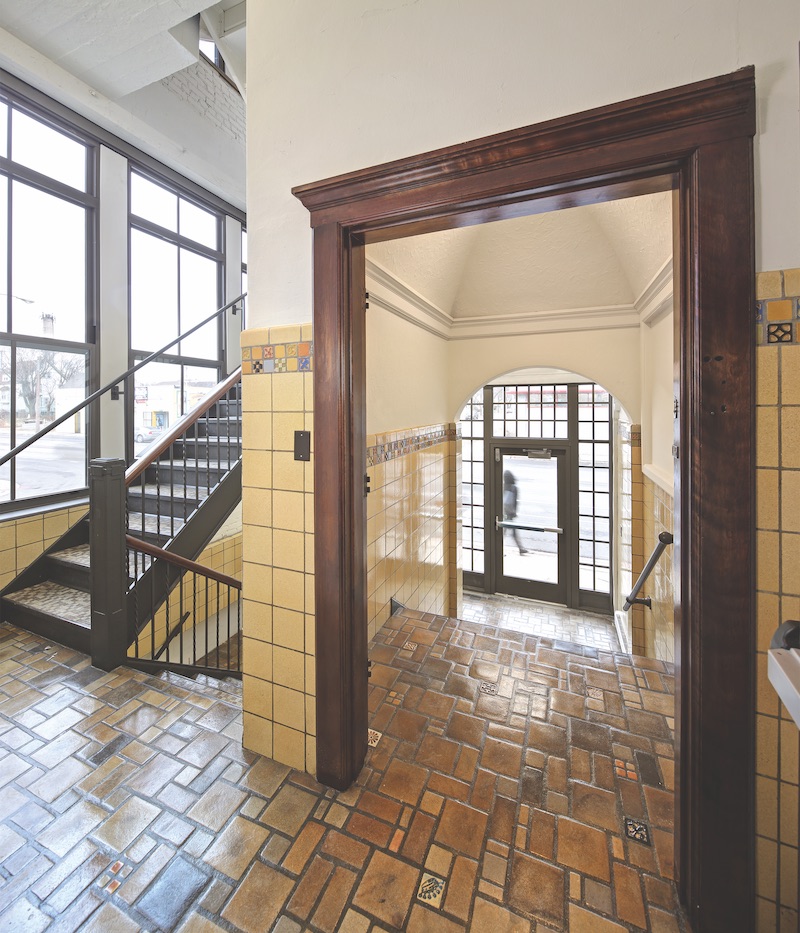 The entry vestibule and stairs with period floor tiles and wainscoting