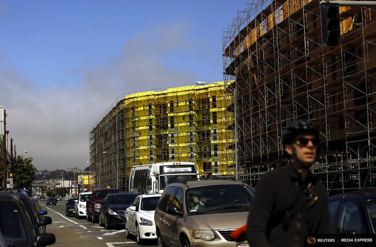 A bicyclist sits in traffic near a housing construction project in San Francisco. Photo: Reuters/Robert Galbraith