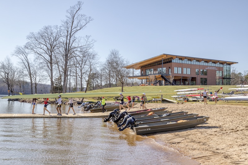 People carrying a boat in front of the Clemson's Outdoor Education Center