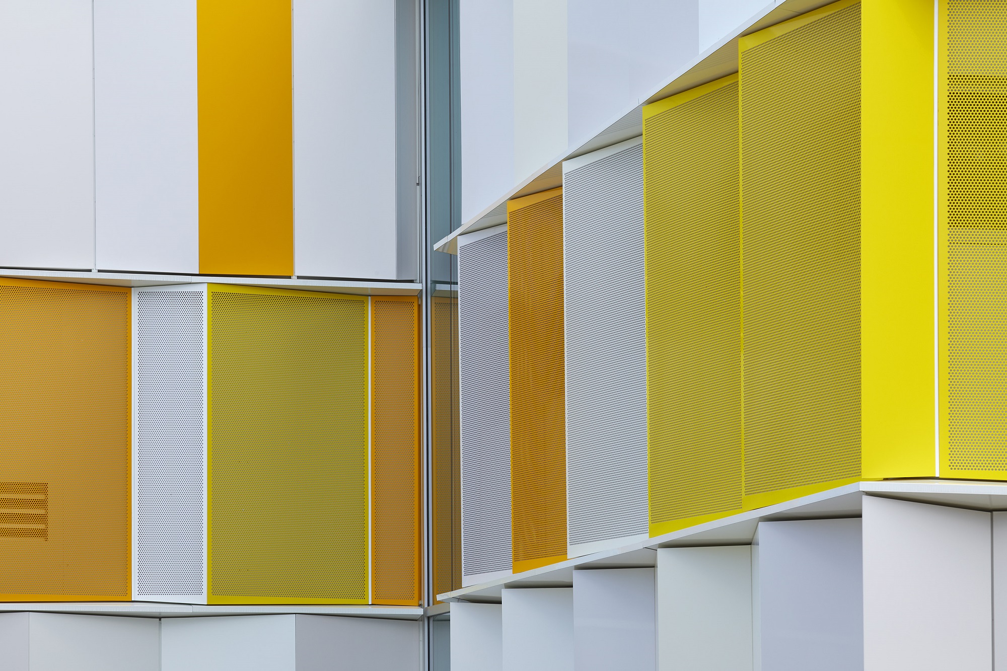 Perforated ALPOLIC metal composite materials in different white and yellow finishes, installed on Fleming College's A Wing