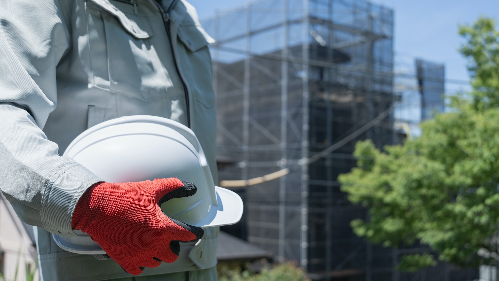 Construction worker holding hard hat at job site
