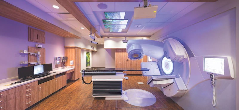 Versa HD radiation therapy machine and supporting tech in a treatment room inside