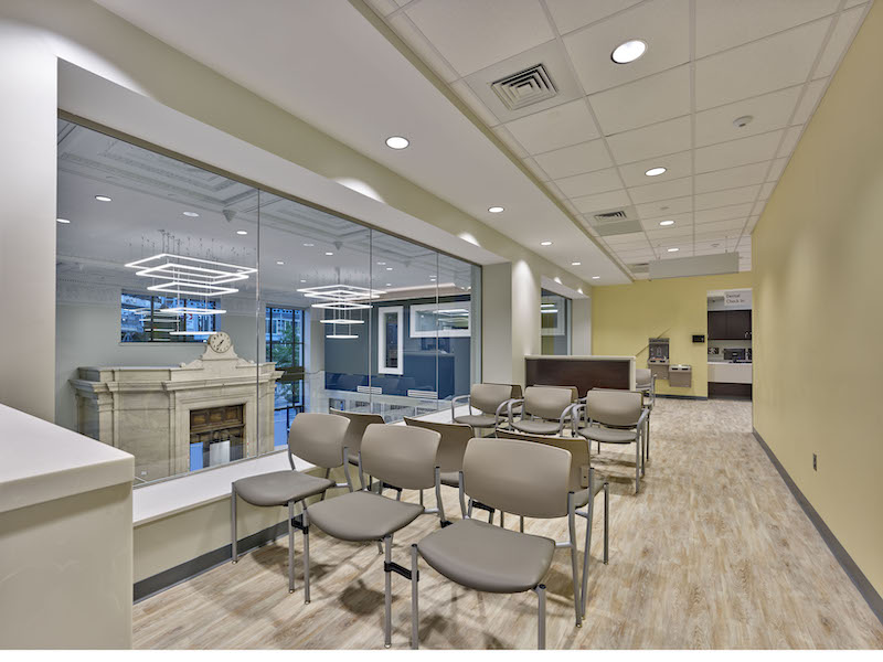 A dental waiting room looks out over the clinic's atrium and onto the street.