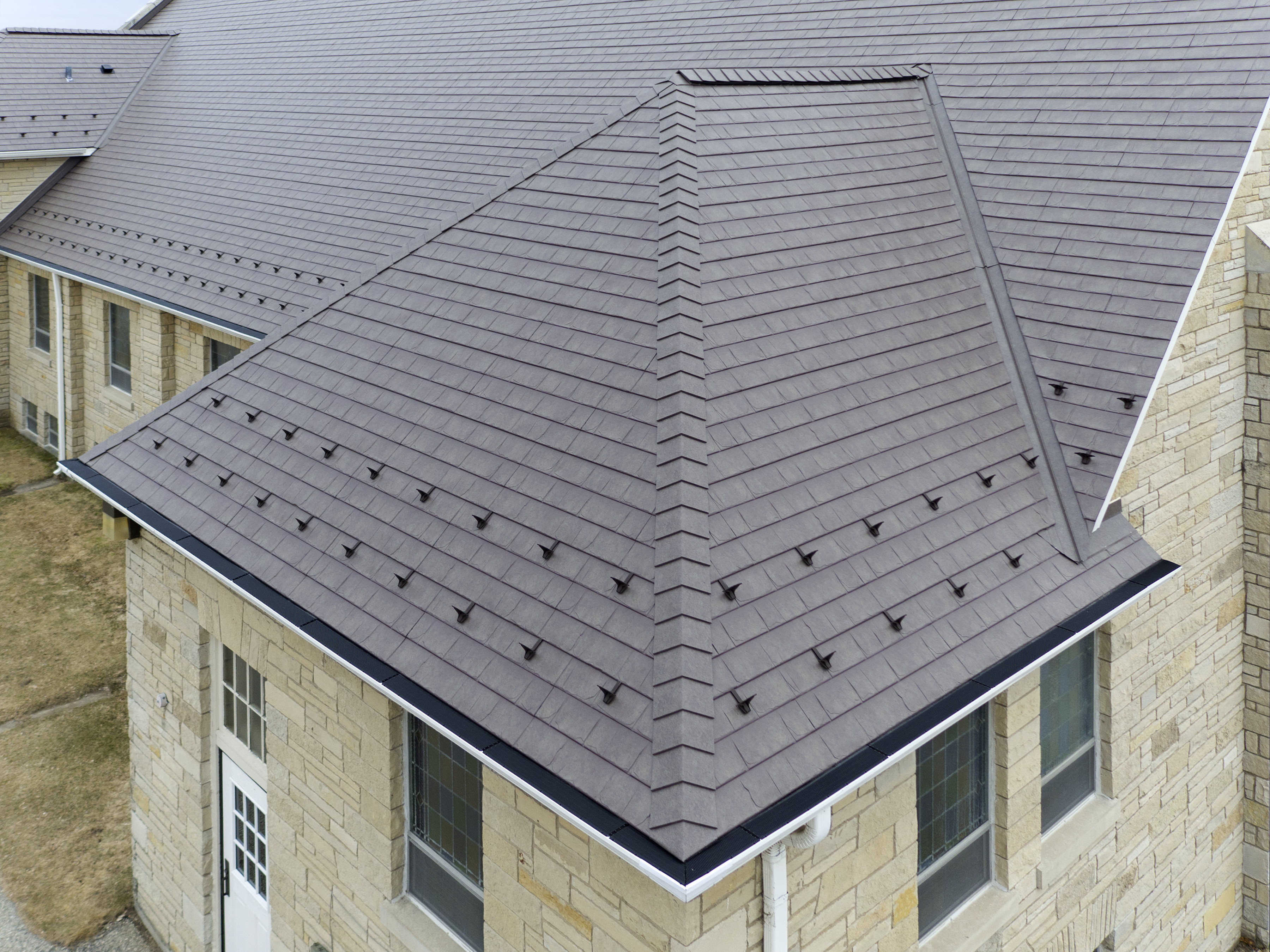 Simulated shingle roofing made from deepdraw steel provides performance advantages such as wind resistance and high solar reflectance. Photo courtesy CertainTeed