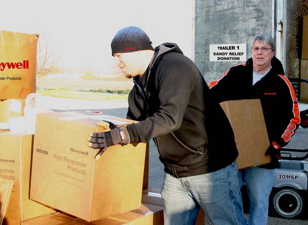 Honeywell employees offloading truck of donated first responder supplies in resp