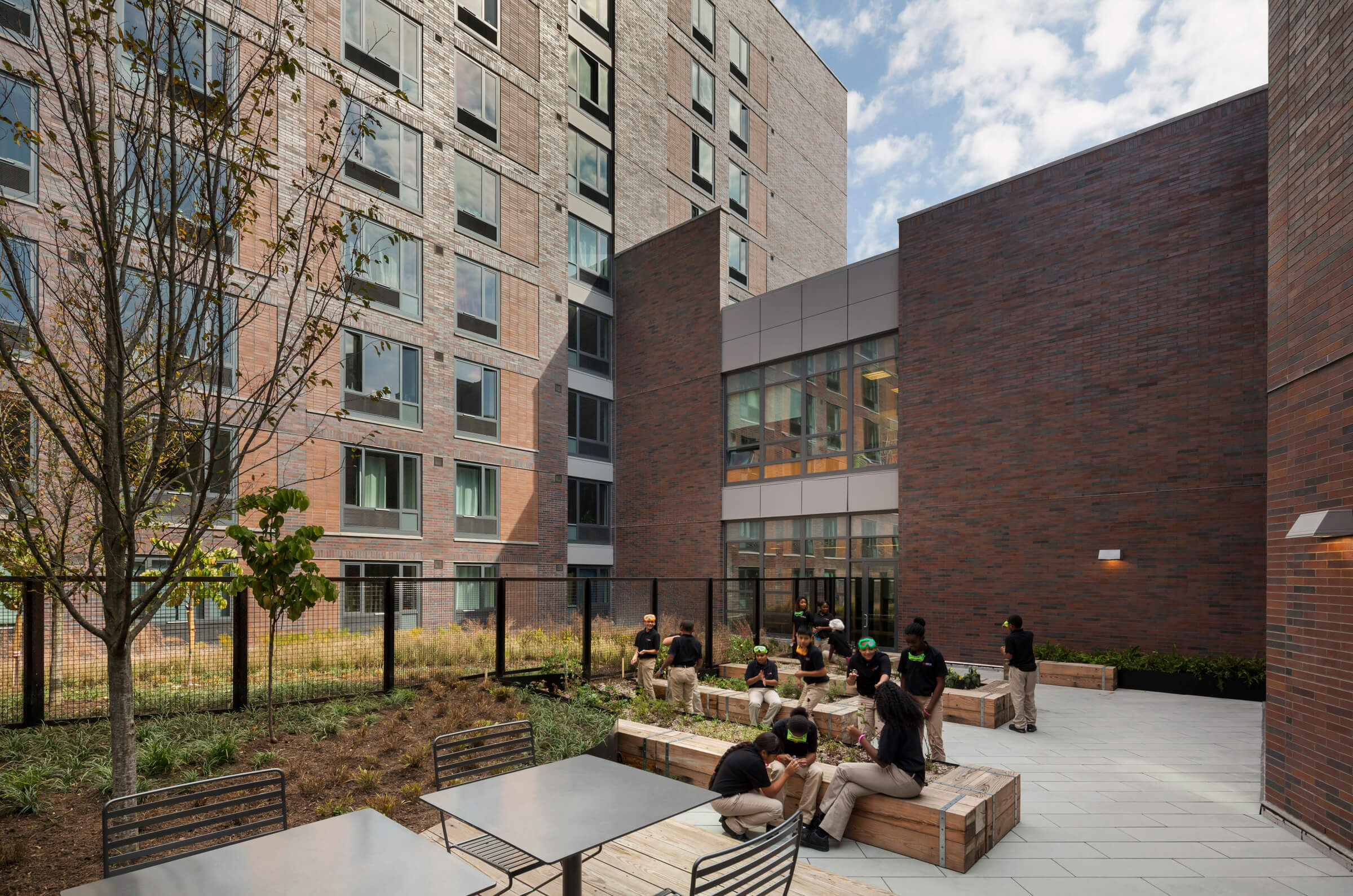 Students sitting in the rooftop garden of the DREAM Charter School affordable housing