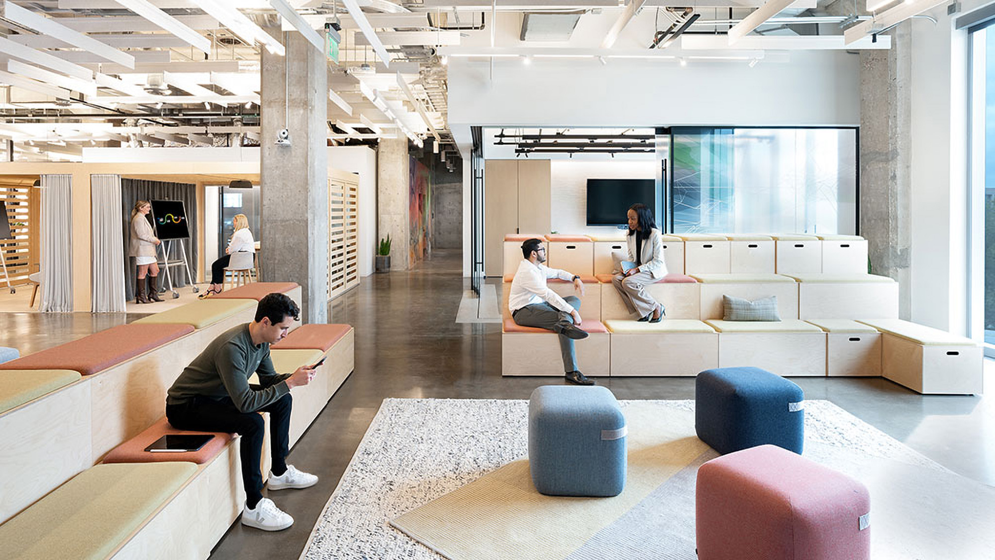 People working and socializing in a variety of workspaces.