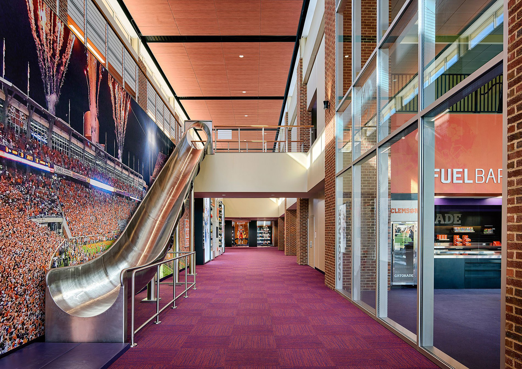 A slide connects the lobby to the concourse at Clemson University’s Alan N. Reeves Football Operations Complex in Clemson, South Carolina