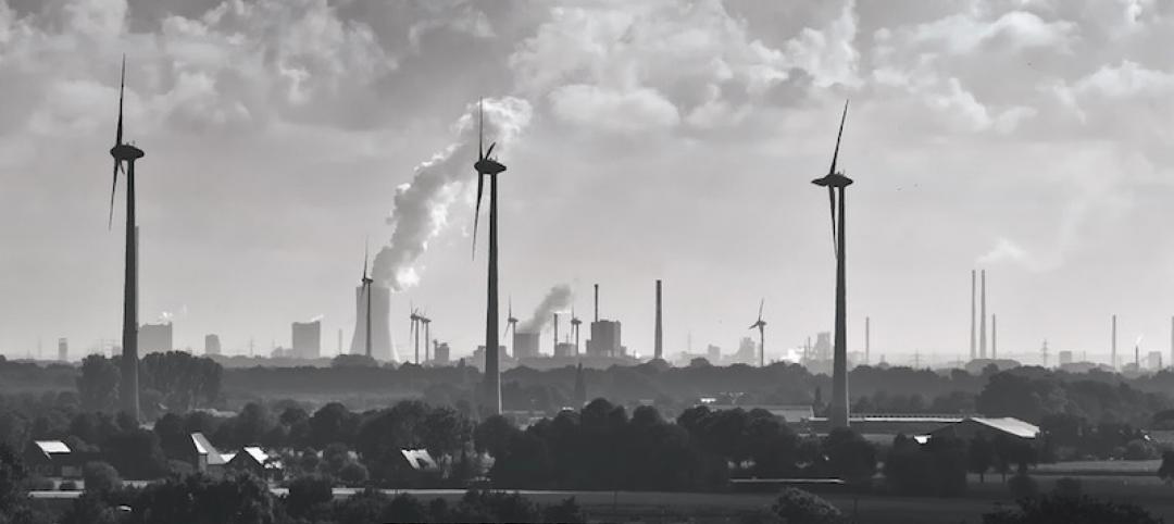 Smokestacks and wind turbines in a rural area