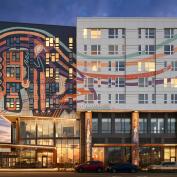Affordable housing multifamily development with artistic exterior at night
